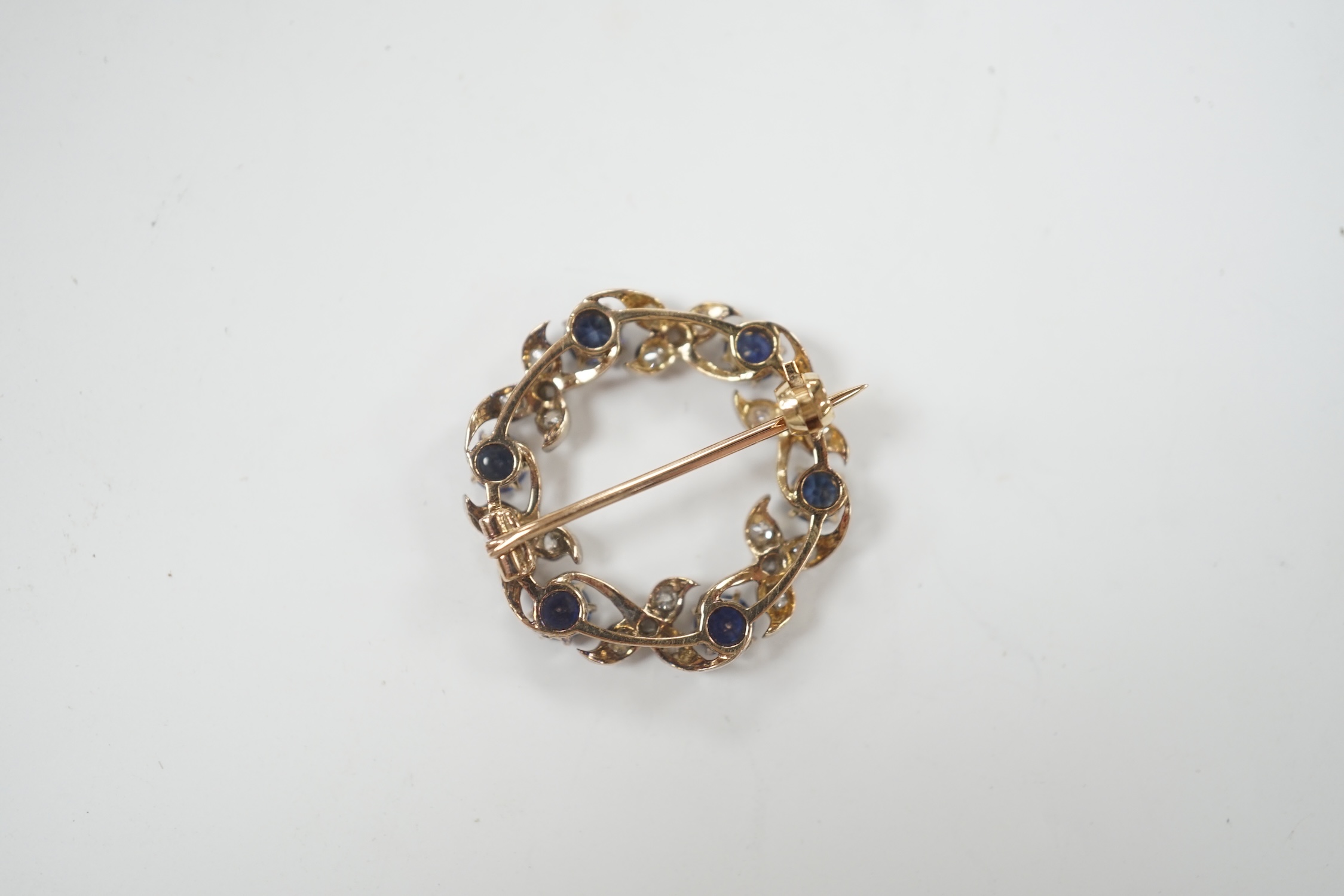 A yellow and white metal, sapphire and diamond cluster set openwork brooch, 24mm, gross weight 4.6 grams.
